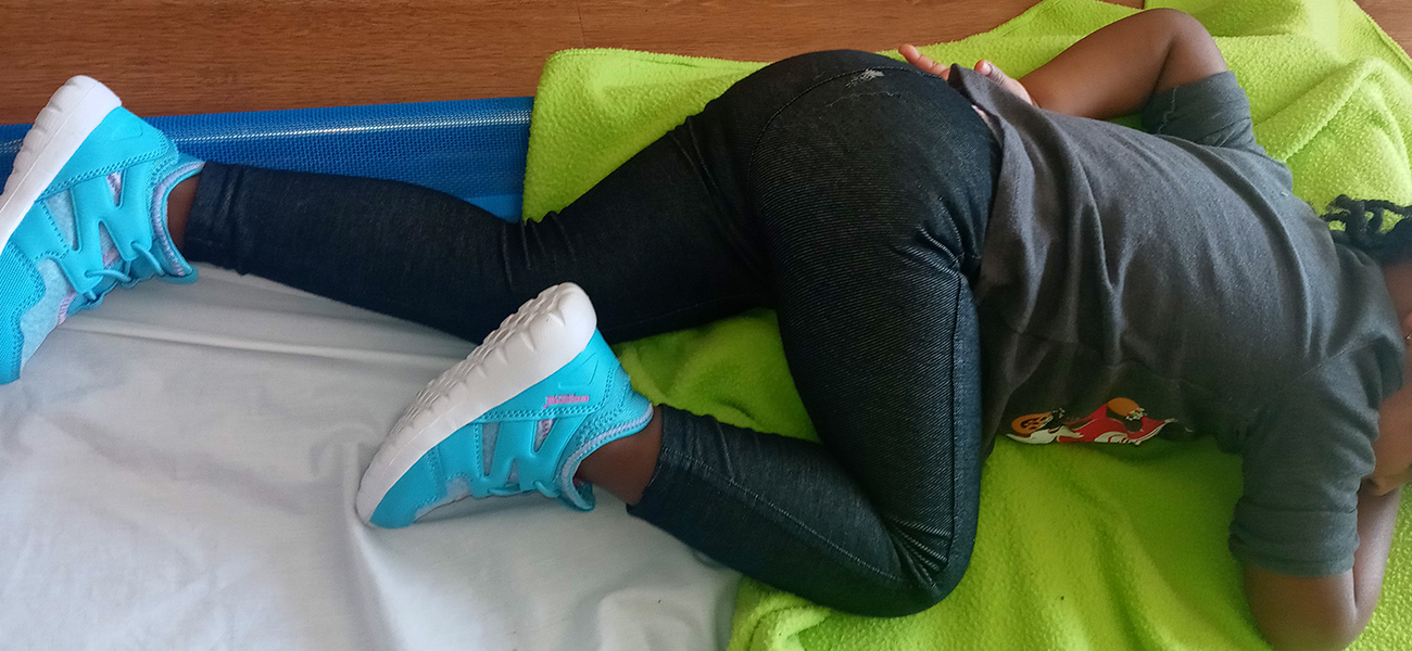 A young girl naps in her tennis shoes
